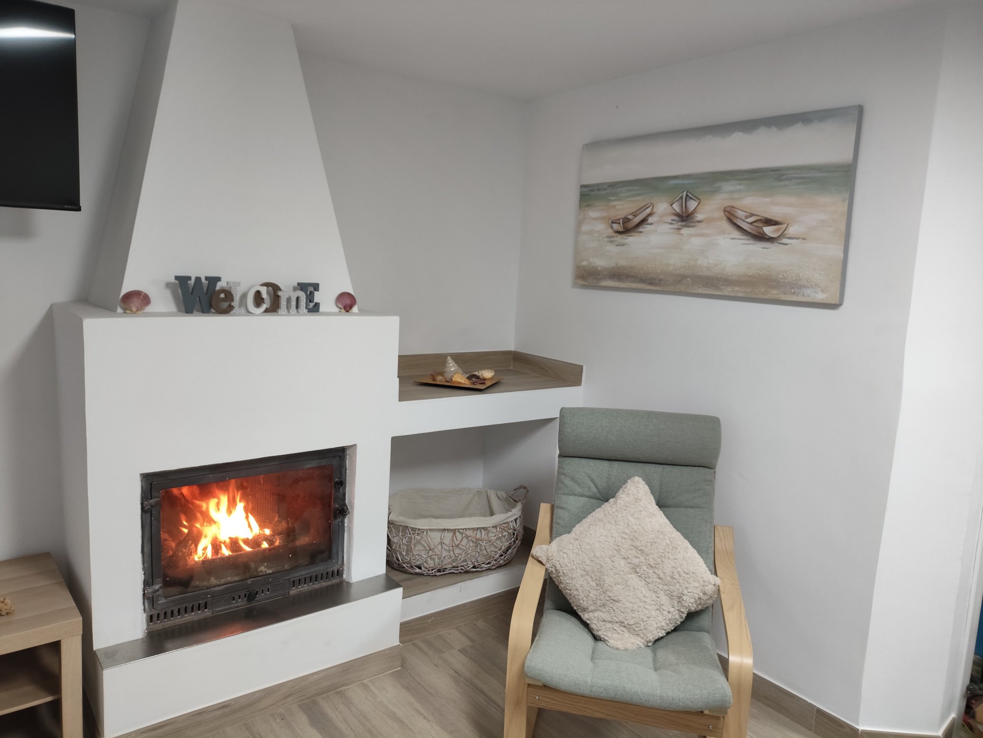 Chimenea encendida junto al sillón del salón